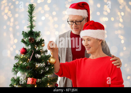 happy senior couple decorating christmas tree Stock Photo