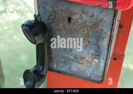 Hanging old phone receiver in old phone booth Stock Photo