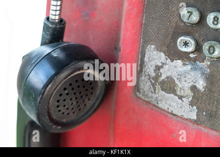 Hanging old phone receiver on white background. Stock Photo