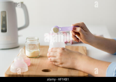 Hands with kettle and bottle making baby milk Stock Photo by  ©Syda_Productions 167539370