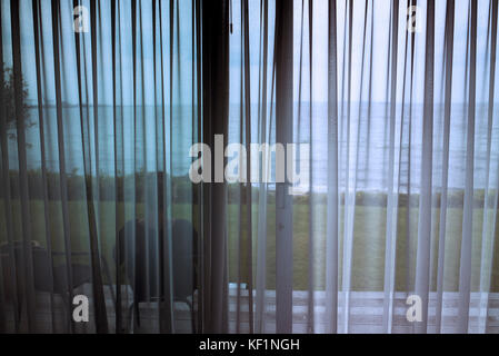 sea view through bedroom net curtains Aalburg Denmark Stock Photo
