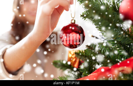 close up of woman hand decorating christmas tree Stock Photo