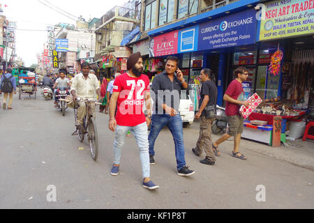 DELHI, INDIA - SEPTEMBER 25 2017: Unidentified people walking at outdoors next to a stores in a dirty streets in Paharganj, Delhi. Delhi is the 2nd most populous city in India after Mumbai Stock Photo