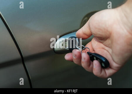 man's hand opens the car door with a key. Stock Photo