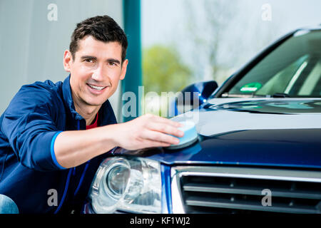 Man using an absorbent towel for drying the surface of a car Stock Photo