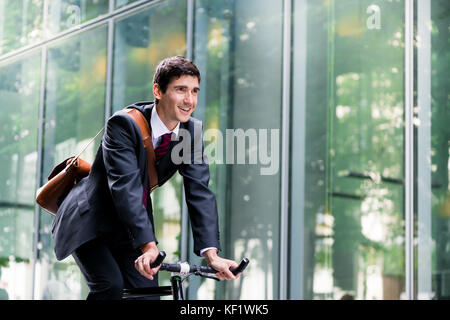 Cheerful young employee riding an utility bicycle in Berlin Stock Photo