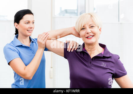 Physio doing shoulder exercises with senior woman Stock Photo