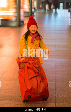 The little girl took the suitcase in the waiting room Stock Photo