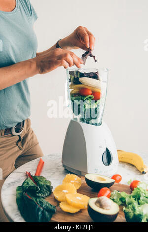 Blender filled with fruits and vegetables Stock Photo