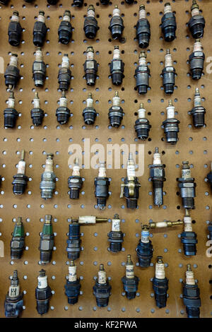 A display of antique engine spark plugs on a wall Stock Photo