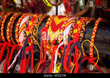 Close up view of colorful bracelets in Ibiza showing / reflecting region's culture and lifestyle. Spanish flag's colours (red and yellow) are dominant Stock Photo