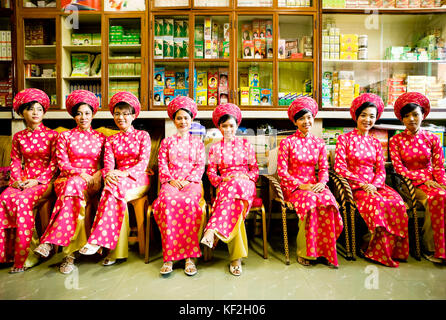 Ho Chi Minh City, Vietnam - January 1, 2009: Group of young Vietnamese women bridesmaids sitting in a pharmacy in Ho Chi Minh City, Vietnam. Stock Photo