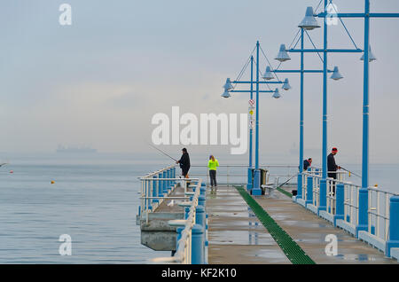 People fishing off modern jetty on foggy morning, Palm Beach jetty, Rockingham, Western Australia Stock Photo