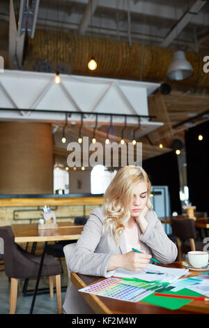 young blonde fashion designer woman drawing new cloth concept at the ...
