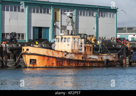 Old rusty tug boat stands moored in port of Reykjavik, Iceland Stock Photo