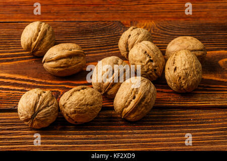 A few ripe walnuts on old wooden background Stock Photo