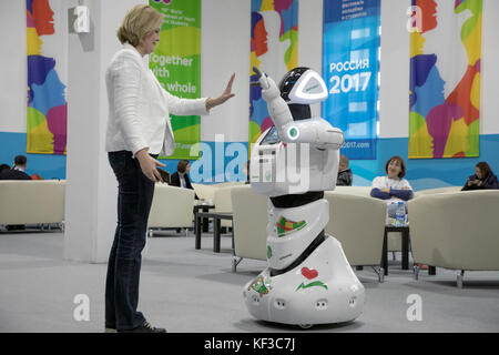A woman trying to communicate with a robot at the 2017 World Festival of Youth and Students in the Olympic Park's main media centre in Sochi, Russia Stock Photo