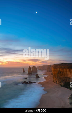Dramatic sunset sky with a crescent moon above The Twelve Apostles, Great Ocean Road, Victoria Australia Stock Photo