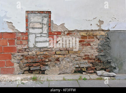 The concept of the abstraction of the urban architecture. The wall of the house looks like a patchwork quilt. Patches made of bricks of different colo Stock Photo