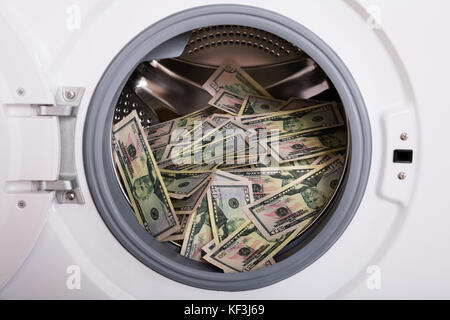 Close-up Of Pile Of Dirty Money Placed In Washing Machine Stock Photo