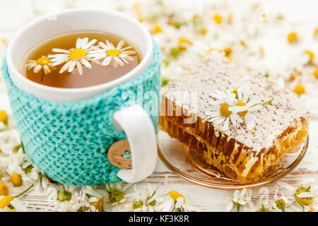 Honeycomb and chamomile tea on white Stock Photo