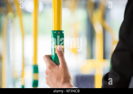 Close-up Of A Businesswoman's Hand Pressing Stop Button On Bus Stock Photo