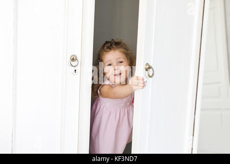 Cute girl in closet smiles Stock Photo