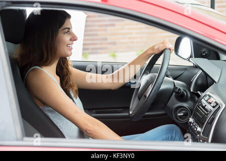 Side View Of Young Happy Woman Sitting Inside Car Stock Photo