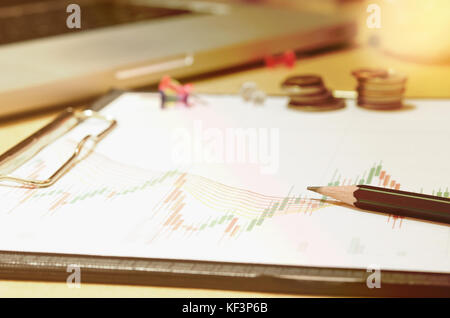 business documents graph financial on  table with laptop computer and coins and diagram. Stock Photo