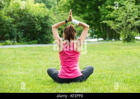 Rear view of young woman practicing yoga tree pose on beach, Dominican ...