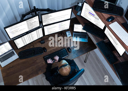 High Angle View Of A Boy Working On Multiple Computers Stock Photo