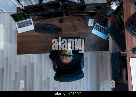 High Angle View Of A Boy Working On Multiple Computers Stock Photo