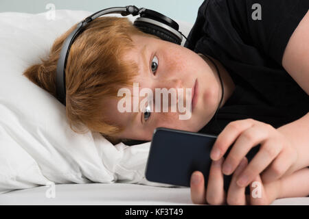 Close-up Of Boy Using Smartphone Listening To Music Stock Photo