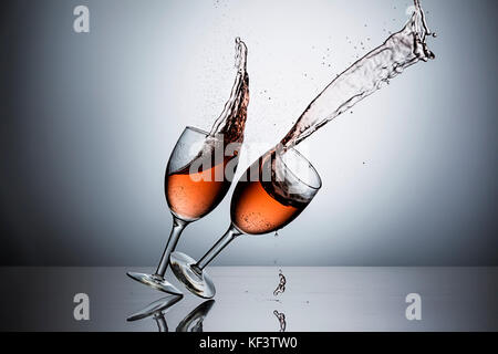 The movement of sliding one wine glass filled with wine into another one. Stock Photo