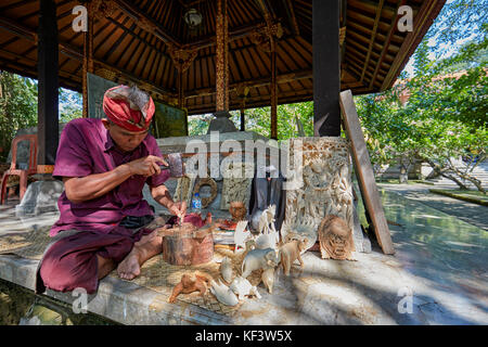 Craftsman carving wood at the Agung Rai Museum of Art (ARMA). Ubud, Bali, Indonesia. Stock Photo