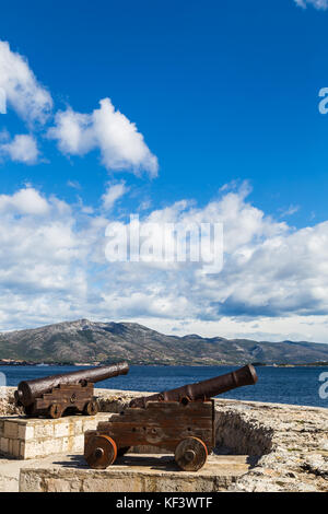 A pair of old cannons face out over the Peljesac Channel from the start of Korculanskog Statuta, a street which runs the length of the tiny peninsula, Stock Photo