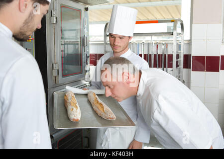 Chef smelling freshly baked baguette Stock Photo