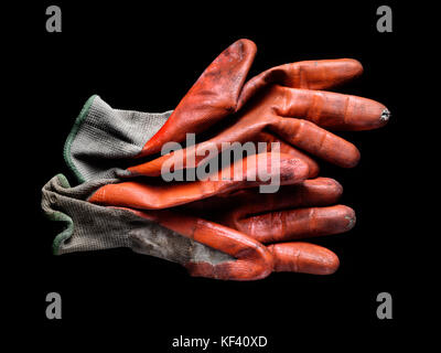 Dirty worn orange rubber coated work gloves on black Stock Photo