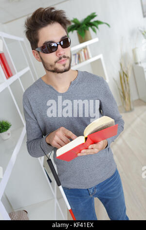 a blind man reading braille Stock Photo