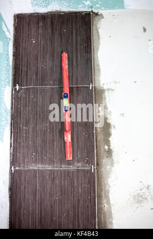 Installing ceramic floor tiles - measuring and cutting the pieces, closeup Stock Photo