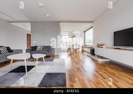 Spacious living room with tv, carpet, table and two couches Stock Photo