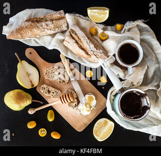 Breakfast set: pot or cezve of coffee, cup on kitchen towel, kumquats, pears, grapefruit Stock Photo