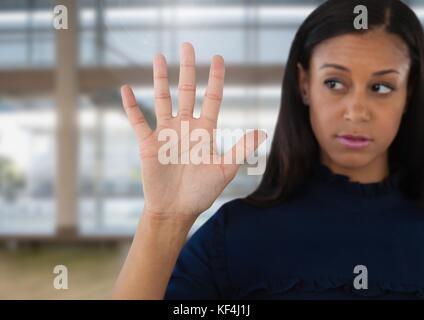 Digital composite of Businesswoman opening hand in front of windows in large hall Stock Photo