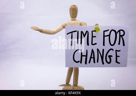 A yellow sticky note post it writing, caption, inscription Time For Change in black ext on a sticky note pinned to board Stock Photo