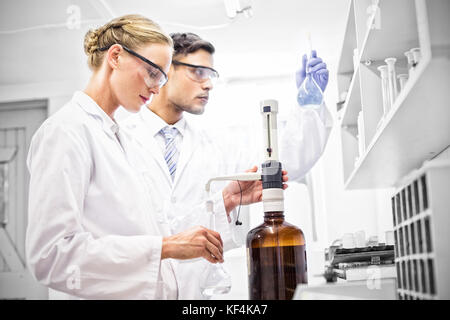 Scientists working attentively with beaker in laboratory Stock Photo