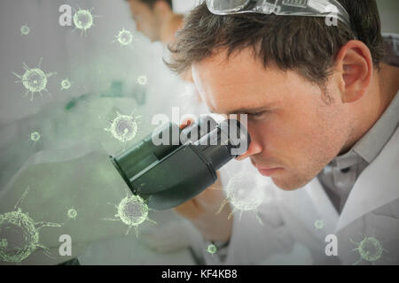 Composite image of green virus against scientist working on microscope Stock Photo