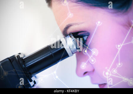 Digitally generated image of molecular structure on screen against darkhaired scientist looking through a microscope Stock Photo