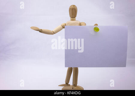 Two white sticky note reminders on a white background holding by the wooden sculpture with text copy space Stock Photo