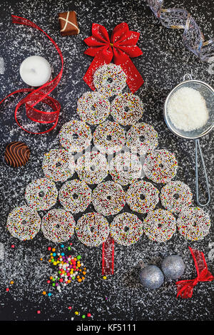 Colored chocolate rings with Christmas decoration on black stone table Stock Photo