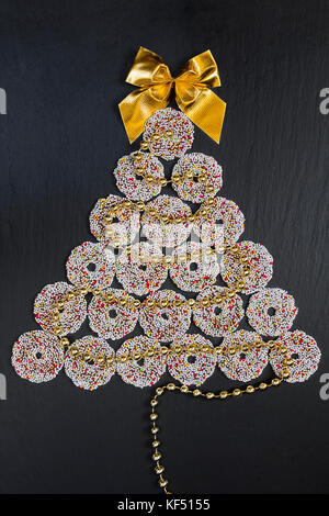 Colored chocolate rings with Christmas decoration on black table Stock Photo
